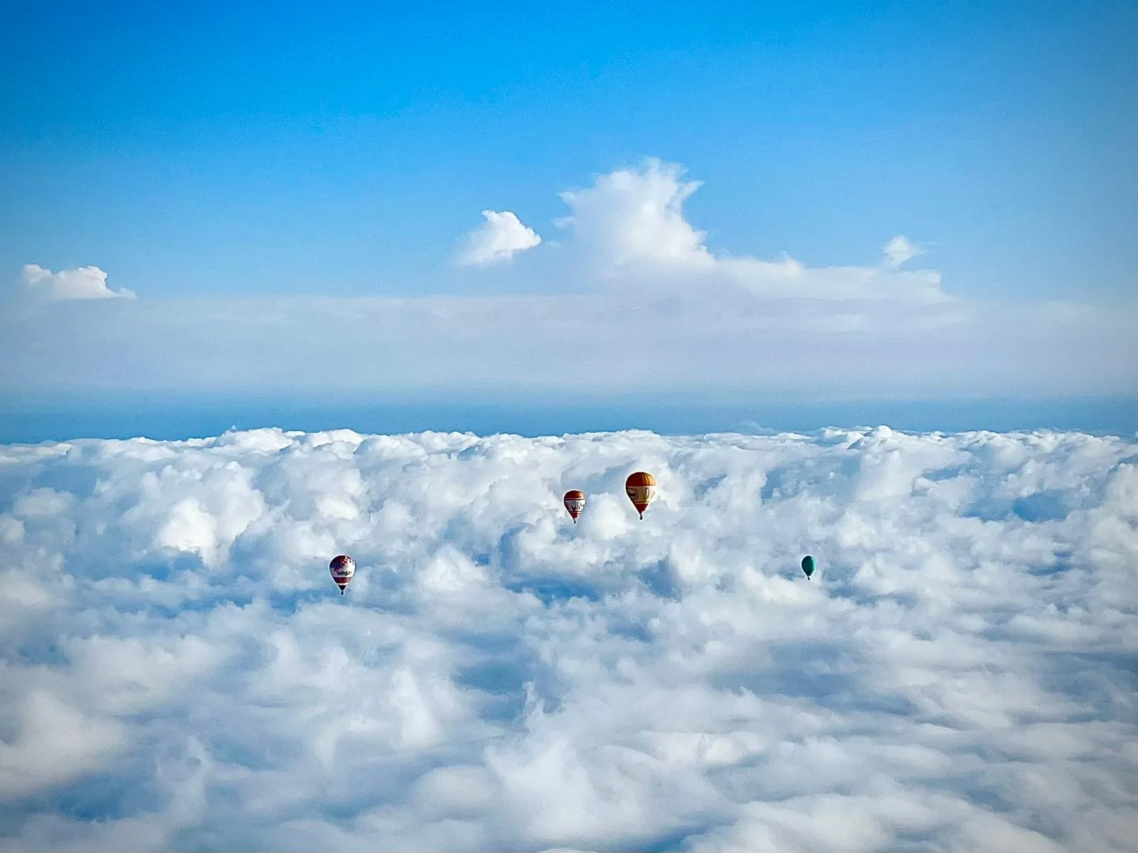 Balões de ar quente acima de um mar de nuvens